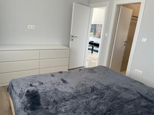 a white bedroom with a bed and a mirror at Pinter apartmant in Smokvica Krmpotska in Krmpote-Vodice