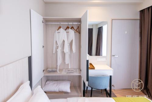 a bedroom with a bed and a sink and a mirror at The Aru Hotel at Aru Suites in Kota Kinabalu