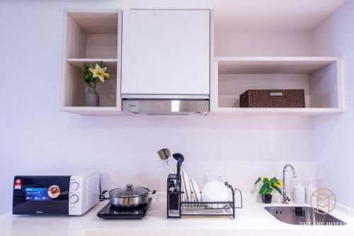 a kitchen counter with a microwave and a sink at The Aru Hotel at Aru Suites in Kota Kinabalu