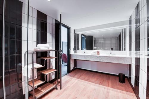 ein Badezimmer mit einem großen Waschbecken und einem großen Spiegel in der Unterkunft COWOOL GRENOBLE in Grenoble