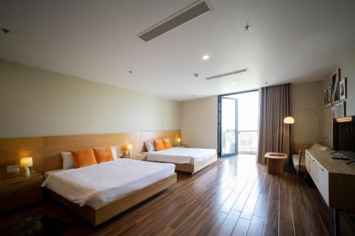 a hotel room with two beds and a large window at Sline Hotel and Apartment in Thôn Trường Giang