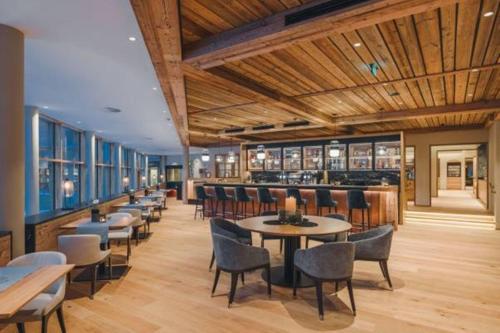 un restaurante con mesas y sillas y un bar en Alpenhotel Montafon, en Schruns