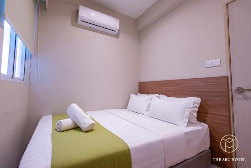 a small room with a bed and a window at The Aru Hotel at Aru Suites in Kota Kinabalu