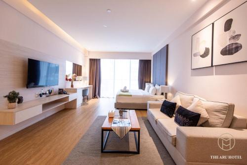 a living room with a couch and a tv at The Aru Hotel at Aru Suites in Kota Kinabalu