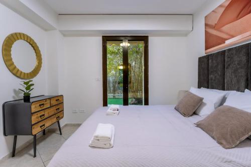 a bedroom with a large bed with a dresser and a mirror at Holysuite David's Village in Jerusalem