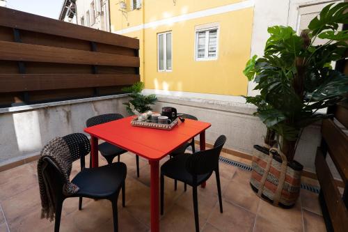 una mesa roja y sillas en el balcón en Center Suite Acebedos, en Santander