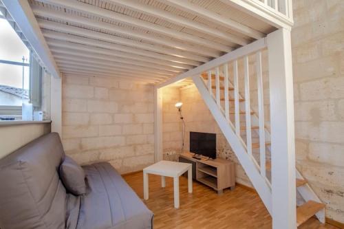 un salon avec un canapé et un escalier dans l'établissement Yani - Grand studio intra-muros cadre exceptionnel, à Avignon