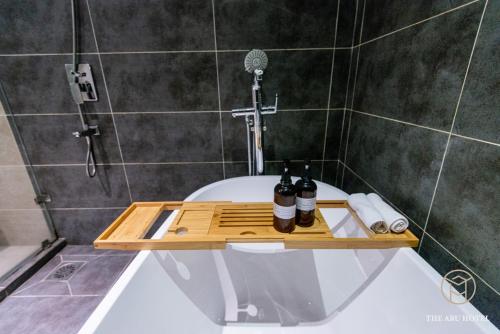 a bathroom with a bath tub with two bottles on it at The Aru Hotel at Aru Suites in Kota Kinabalu
