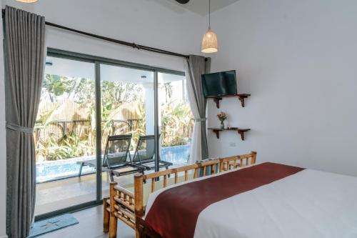 sypialnia z łóżkiem i dużym oknem w obiekcie Hidden Gem w Hoi An