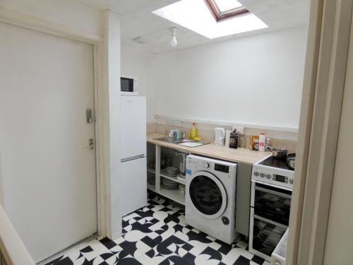 a kitchen with a stove and a washing machine at Bridge Street En Suite Rooms in Merthyr Tydfil