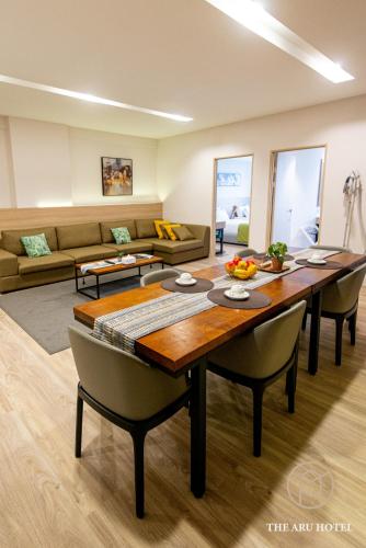 a living room with a wooden table and chairs at The Aru Hotel at Aru Suites in Kota Kinabalu