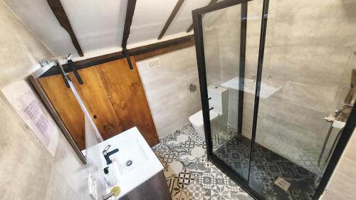 a bathroom with a glass shower and a sink at Hotel Tuul Etxea in Galdakao
