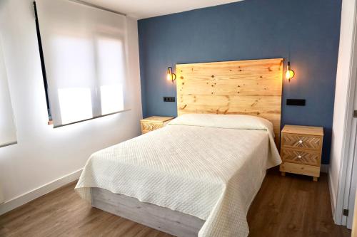 Schlafzimmer mit einem großen Bett mit einem Kopfteil aus Holz in der Unterkunft Casa El Acebal in Llanes