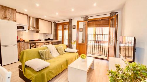 uma sala de estar com um sofá amarelo e uma cozinha em PRECIOSO PISO EN PLENO CENTRO Con PARKING OPCIONAL em Granada