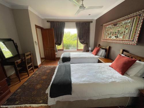 a hotel room with two beds and a television at Ha'Penny Hill in Tzaneen