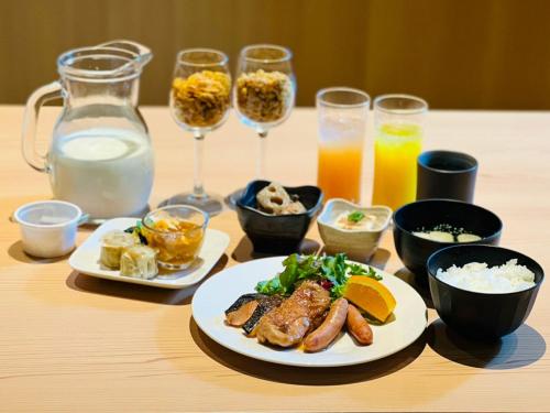 a table with plates of food and glasses of drinks at APA Hotel Higashi Shinjuku Kabukicho in Tokyo