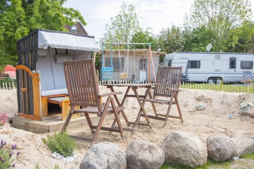 two chairs and a table in front of a house at Ferienwohnungen Fehmarn mit Parkplatz in Petersdorf in Fehmarn