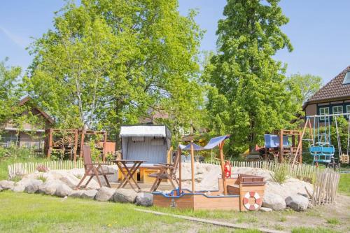 a playground with a table and chairs in a yard at Ferienwohnungen Fehmarn mit Parkplatz in Petersdorf in Fehmarn