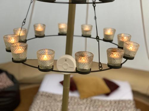 a chandelier with candles on top of a table at Home Farm Radnage Glamping Bell Tent 8, with Log Burner and Fire Pit in High Wycombe