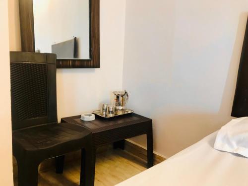 a bedroom with a table with a chair and a mirror at Hotel Diamond in Secunderabad