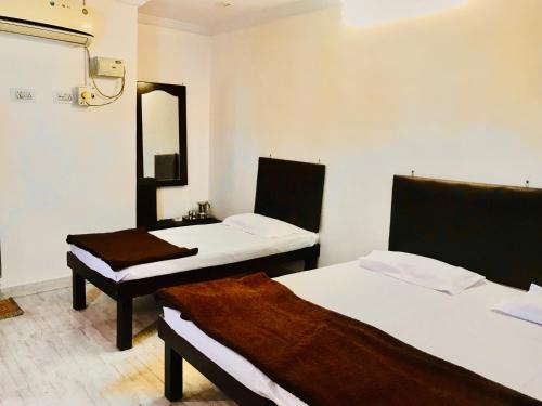 a room with two beds with a mirror and a sink at Hotel Diamond in Secunderabad