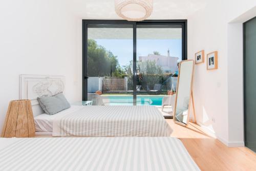 a bedroom with two beds and a pool at Villa 91 by ALGARTUR in Tavira