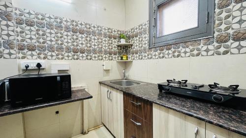 a small kitchen with a sink and a stove at BluO 1BHK Medanta Medicity, Kitchen, Balcony, Lift in Gurgaon