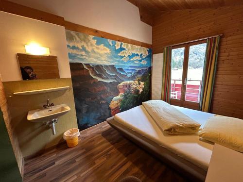 a bedroom with a bed and a sink in it at Alpine Base Hostel - Adults only in Lauterbrunnen