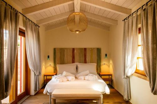 a bedroom with a white bed with towels on it at Tenuta dei Mori-Wine Relais Events in Villanova