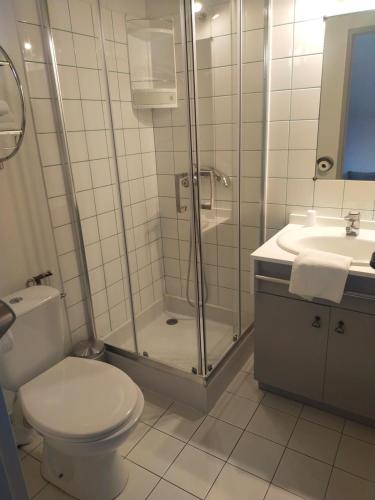 ein Bad mit einer Dusche, einem WC und einem Waschbecken in der Unterkunft Hôtel Bon Repos in Barbezieux