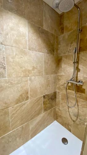 une salle de bain avec une douche avec pommeau de douche dans l'établissement Les Papillons du Ventoux - La Petite Tortue - één slaapkamer met terras, à Malaucène