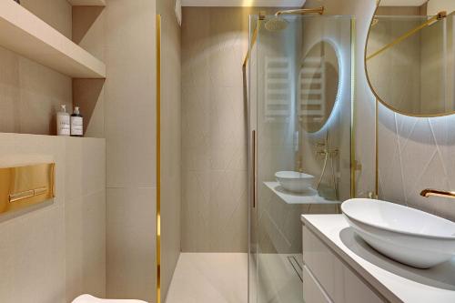 a bathroom with a sink and a glass shower at Downtown Apartments Riverside Granaria Deluxe in Gdańsk