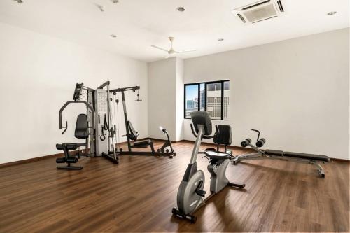 - une salle de sport avec tapis de course et vélos d'exercice dans l'établissement Puchong Setiawalk Residence By Iconique Espace, à Puchong