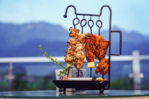 a bunch of food on a stand on a table at Click Collection The Abode, Dharamshala in Dharamshala