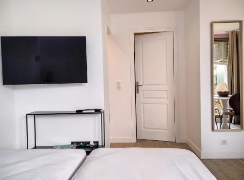 une chambre avec un lit et une télévision à écran plat au mur dans l'établissement Résidence Graziella studio 511, à Juan-les-Pins