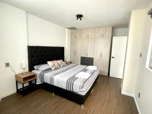 a bedroom with a large bed and a wooden floor at Brand-new 2 bedroom apartment Sopocachi in La Paz