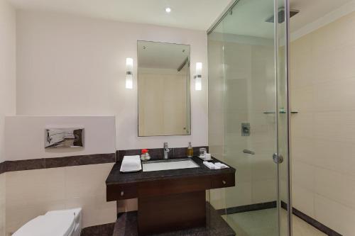ein Badezimmer mit Waschbecken und Dusche in der Unterkunft Sarovar Portico Jaipur in Jaipur