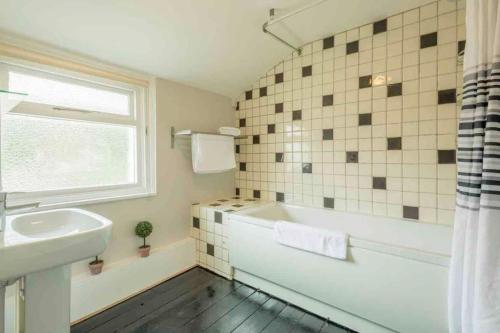 ein Badezimmer mit einer weißen Badewanne und einem Waschbecken in der Unterkunft Cambridge 3 bedroom flat with private parking in Cambridge
