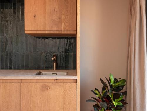 a kitchen with a sink in a wooden cabinet at Can Verí Suites in Sóller
