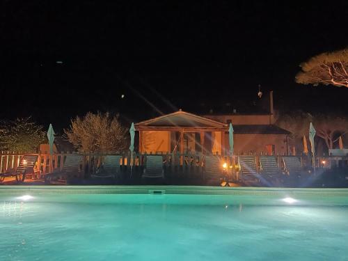 uma piscina à noite com um gazebo em Il Cipresso em Cecina