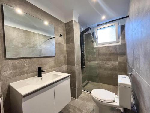 a bathroom with a white toilet and a sink at Giovanni Group Apartments in Sivota