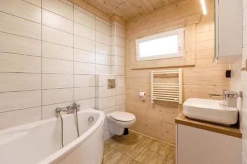 ein Badezimmer mit Badewanne, Toilette und Waschbecken in der Unterkunft Collins Beach in Ustronie Morskie