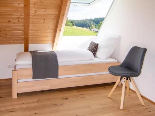 Bett in einem Zimmer mit einem Stuhl und einem Fenster in der Unterkunft Haus Mühlenfranzenhof in Schönwald