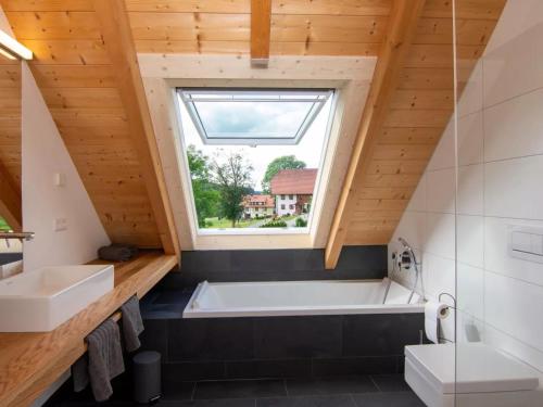 baño con bañera grande y ventana en Haus Mühlenfranzenhof en Schönwald