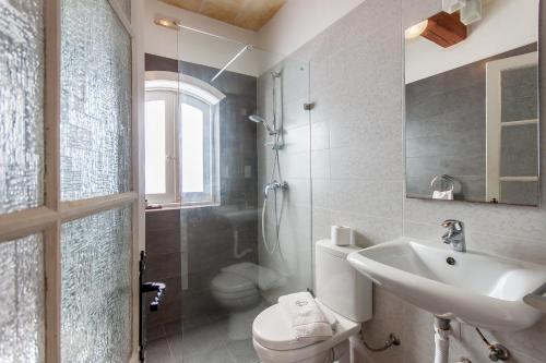 a bathroom with a sink and a toilet and a shower at Twilight Gozitan Farmhouse With Pool - Happy Rentals in Għammar