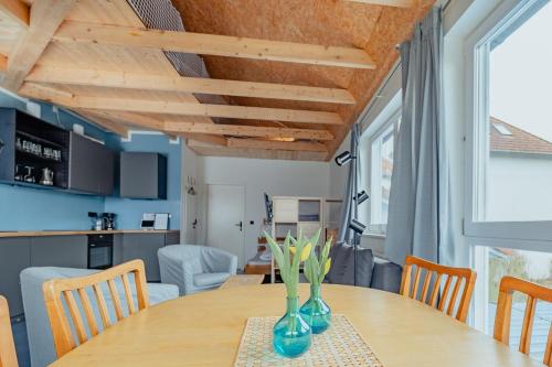 a dining room with a wooden table with vases on it at Ferienwohnungen Fehmarn mit Parkplatz in Petersdorf in Fehmarn
