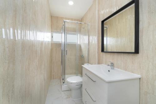 y baño con aseo, lavabo y espejo. en Estrela Do Mar Apartment by Olala Homes en Cascais