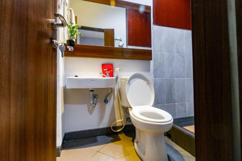 Łazienka z białą toaletą i umywalką w obiekcie RedDoorz near Kebon Jeruk Jakarta w Dżakarcie