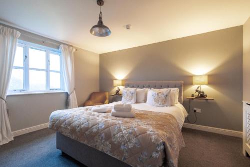 a bedroom with a large bed and a window at White Hart Inn in Blythburgh