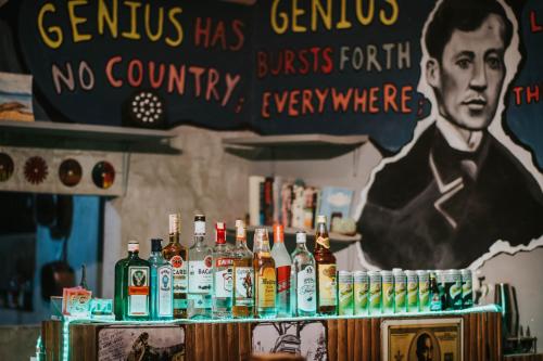 um bar com garrafas de álcool numa mesa em Nomad Homestay em Moalboal